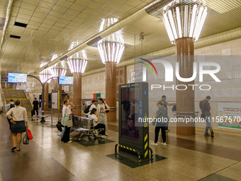 Passengers stay on the platform of the Demiivska metro station after the traffic launches following nine months of repairs in the tunnel bet...