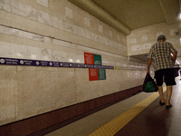 Passengers stay on the platform of the Demiivska metro station after the traffic launches following nine months of repairs in the tunnel bet...