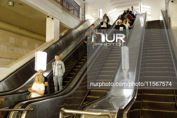 Passengers use escalators at the Demiivska metro station after the traffic launches following nine months of repairs in the tunnel between D...