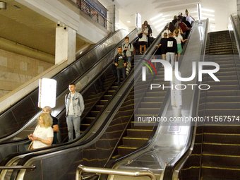 Passengers use escalators at the Demiivska metro station after the traffic launches following nine months of repairs in the tunnel between D...