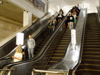 Passengers use escalators at the Demiivska metro station after the traffic launches following nine months of repairs in the tunnel between D...