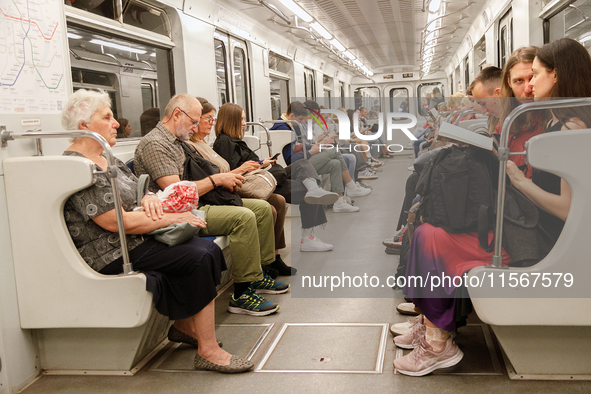 Passengers are in a carriage of a Kyiv Metro train at the Demiivska metro station after the traffic relaunches following nine months of repa...