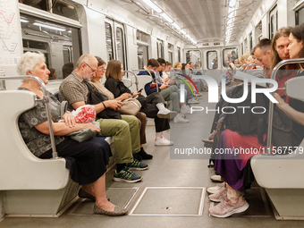 Passengers are in a carriage of a Kyiv Metro train at the Demiivska metro station after the traffic relaunches following nine months of repa...