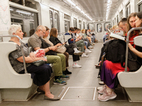 Passengers are in a carriage of a Kyiv Metro train at the Demiivska metro station after the traffic relaunches following nine months of repa...