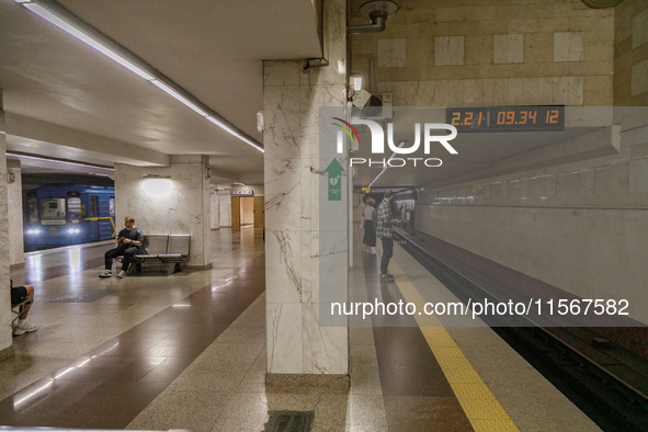 Passengers stay on the platform of the Demiivska metro station after the traffic launches following nine months of repairs in the tunnel bet...