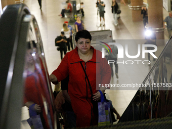 Passengers use escalators at the Demiivska metro station after the traffic launches following nine months of repairs in the tunnel between D...