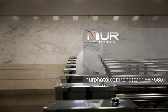 A passenger in a hoodie walks through the turnstiles at the Demiivska metro station after the traffic launches following nine months of repa...