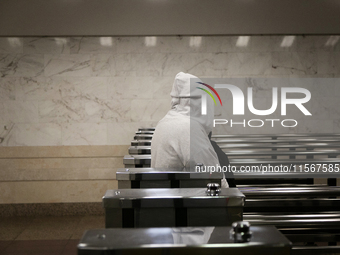 A passenger in a hoodie walks through the turnstiles at the Demiivska metro station after the traffic launches following nine months of repa...