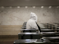 A passenger in a hoodie walks through the turnstiles at the Demiivska metro station after the traffic launches following nine months of repa...