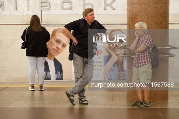 Passengers stay on the platform of the Demiivska metro station after the traffic launches following nine months of repairs in the tunnel bet...