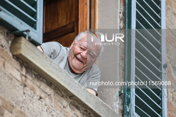 An elderly fan looks out of a window during the 72nd Tour of Tuscany, Coppa Sabatini, in Peccioli, Italy, on September 12, 2024. 