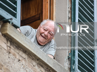 An elderly fan looks out of a window during the 72nd Tour of Tuscany, Coppa Sabatini, in Peccioli, Italy, on September 12, 2024. (