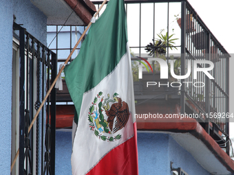 A Mexican flag hangs on a window of a house on the occasion of the national holidays in Mexico City, Mexico, on September 12, 2024. (