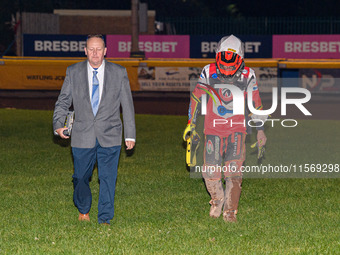 Belle Vue Colts' guest rider Max James (left) walks back to the pits with the Clerk of the Course, Neville Stanley, after his fall during th...