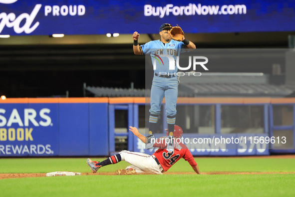 New York's Finest 2B Jose Ortiz #13 goes airborne as New York's Bravest Dan Quinn #34 steals 2B during the baseball game in 'Battle of Badge...