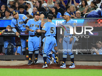 New York's Finest Anthony Maisano #51 is congratulated after scoring during the baseball game against the FDNY baseball team in the 'Battle...