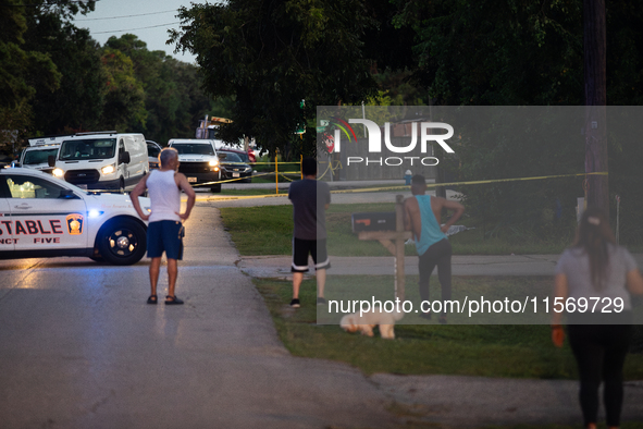 Spectators gather outside the crime scene tape as police investigate a shooting on September 12, 2024. 