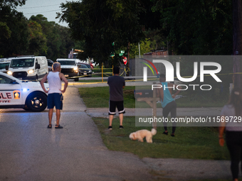 Spectators gather outside the crime scene tape as police investigate a shooting on September 12, 2024. (