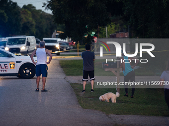 Spectators gather outside the crime scene tape as police investigate a shooting on September 12, 2024. (