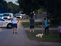 Spectators gather outside the crime scene tape as police investigate a shooting on September 12, 2024. (