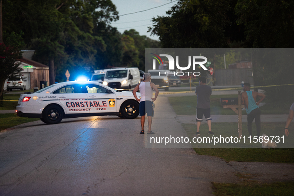 Spectators gather outside the crime scene tape as police investigate a shooting on September 12, 2024. 