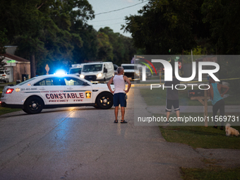 Spectators gather outside the crime scene tape as police investigate a shooting on September 12, 2024. (