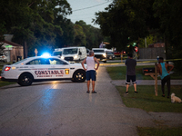 Spectators gather outside the crime scene tape as police investigate a shooting on September 12, 2024. (