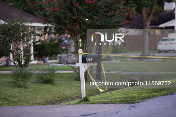 Crime scene tape ties around a neighboring house's mailbox after a shooting in City, Country, on September 12, 2024. 