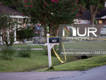 Crime scene tape ties around a neighboring house's mailbox after a shooting in City, Country, on September 12, 2024. (