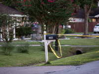 Crime scene tape ties around a neighboring house's mailbox after a shooting in City, Country, on September 12, 2024. (