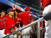 John Giakas #9 of New York's Bravest is congratulated after scoring during the baseball game against the NYPD baseball team in the 'Battle o...