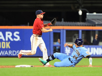 Brian Luebcke #4 fields and throws to first base as PJ Ragone #24 slides into second base during the baseball game against the NYPD baseball...