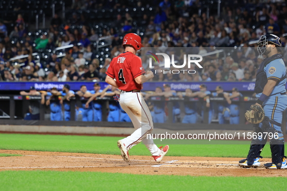 New York's Bravest Brian Luebcke #4 is congratulated after scoring during the baseball game against the NYPD baseball team in the 'Battle of...