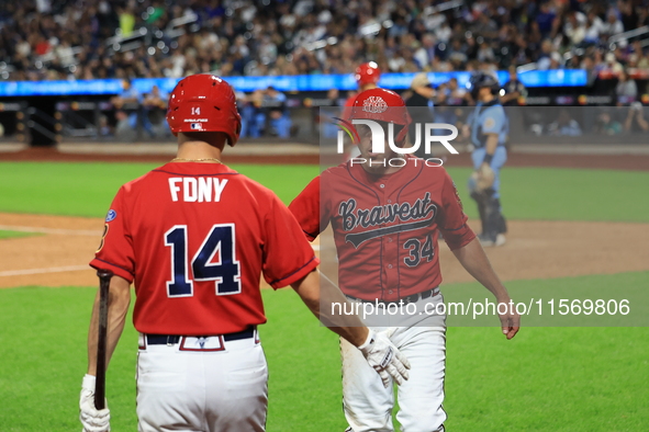 New York's Bravest Dan Quinn #34 is congratulated after scoring during the baseball game against the NYPD baseball team in the 'Battle of Ba...