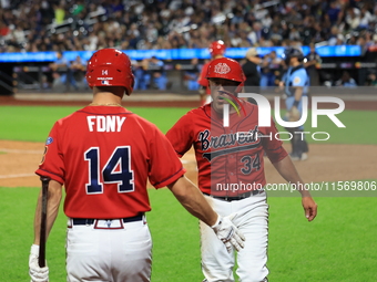 New York's Bravest Dan Quinn #34 is congratulated after scoring during the baseball game against the NYPD baseball team in the 'Battle of Ba...