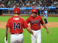 New York's Bravest Dan Quinn #34 is congratulated after scoring during the baseball game against the NYPD baseball team in the 'Battle of Ba...