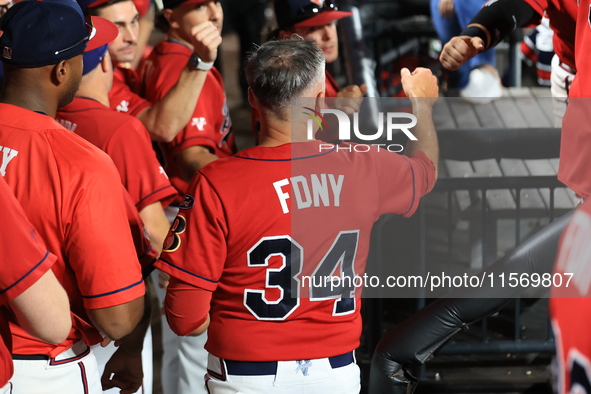 New York's Bravest Dan Quinn #34 is congratulated after scoring during the baseball game against the NYPD baseball team in the 'Battle of Ba...