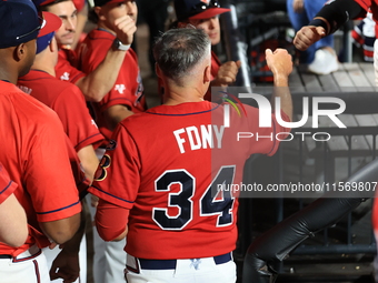 New York's Bravest Dan Quinn #34 is congratulated after scoring during the baseball game against the NYPD baseball team in the 'Battle of Ba...