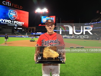 Dan Quinn #34 of New York's Bravest holds up retired golden spikes after playing his final game for FDNY after the 'Battle of Badges' at Cit...