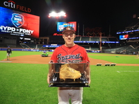 Dan Quinn #34 of New York's Bravest holds up retired golden spikes after playing his final game for FDNY after the 'Battle of Badges' at Cit...