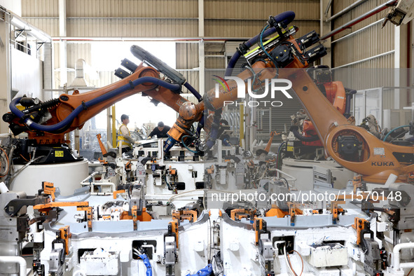 Robots rush to make sheet metal products for car bodies at a production workshop of an intelligent manufacturing enterprise in Fuzhou, Fujia...