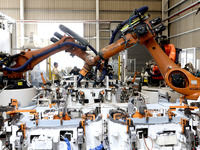 Robots rush to make sheet metal products for car bodies at a production workshop of an intelligent manufacturing enterprise in Fuzhou, Fujia...