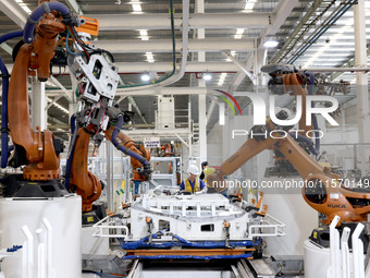 Robots rush to make sheet metal products for car bodies at a production workshop of an intelligent manufacturing enterprise in Fuzhou, Fujia...