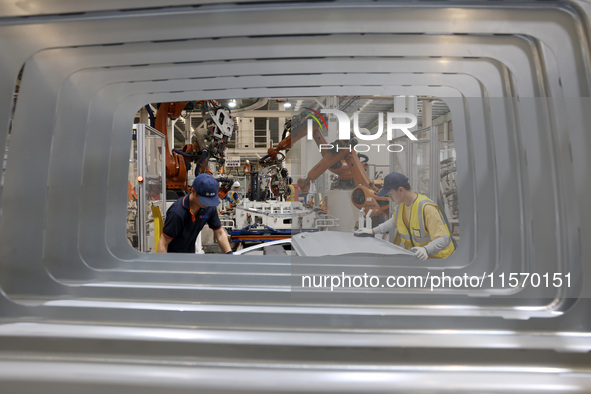 A worker rushes to make auto body sheet metal parts at a production workshop of an intelligent manufacturing enterprise in Fuzhou, China, on...