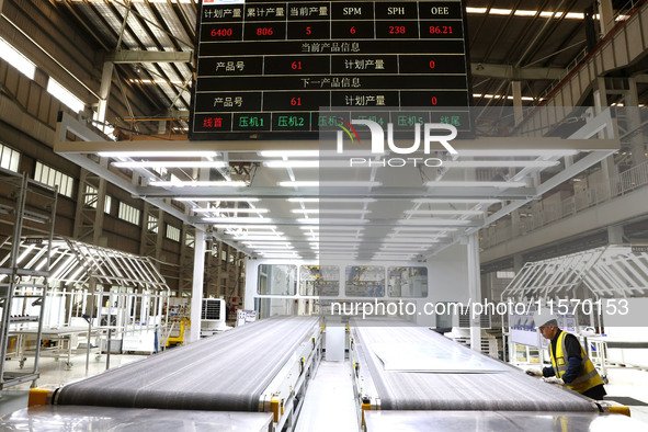 A worker rushes to make auto body sheet metal parts at a production workshop of an intelligent manufacturing enterprise in Fuzhou, China, on...