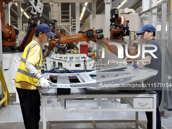 A worker rushes to make auto body sheet metal parts at a production workshop of an intelligent manufacturing enterprise in Fuzhou, China, on...