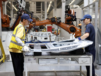 A worker rushes to make auto body sheet metal parts at a production workshop of an intelligent manufacturing enterprise in Fuzhou, China, on...