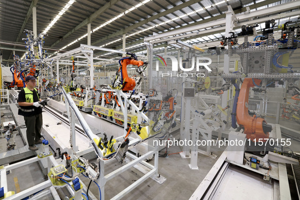 A technician debuts an intelligent robot arm at a production workshop of an intelligent manufacturing enterprise in Fuzhou, China, on Septem...