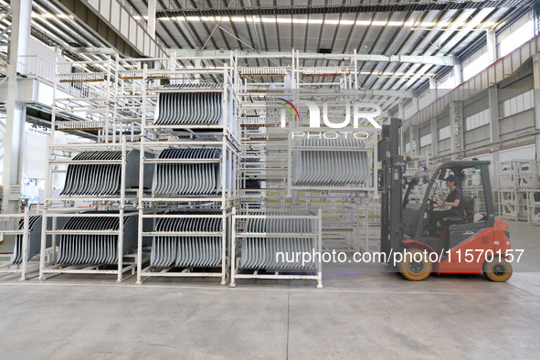 A worker carries a car body sheet metal product at a production workshop of an intelligent manufacturing enterprise in Fuzhou, China, on Sep...