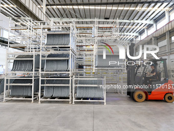 A worker carries a car body sheet metal product at a production workshop of an intelligent manufacturing enterprise in Fuzhou, China, on Sep...